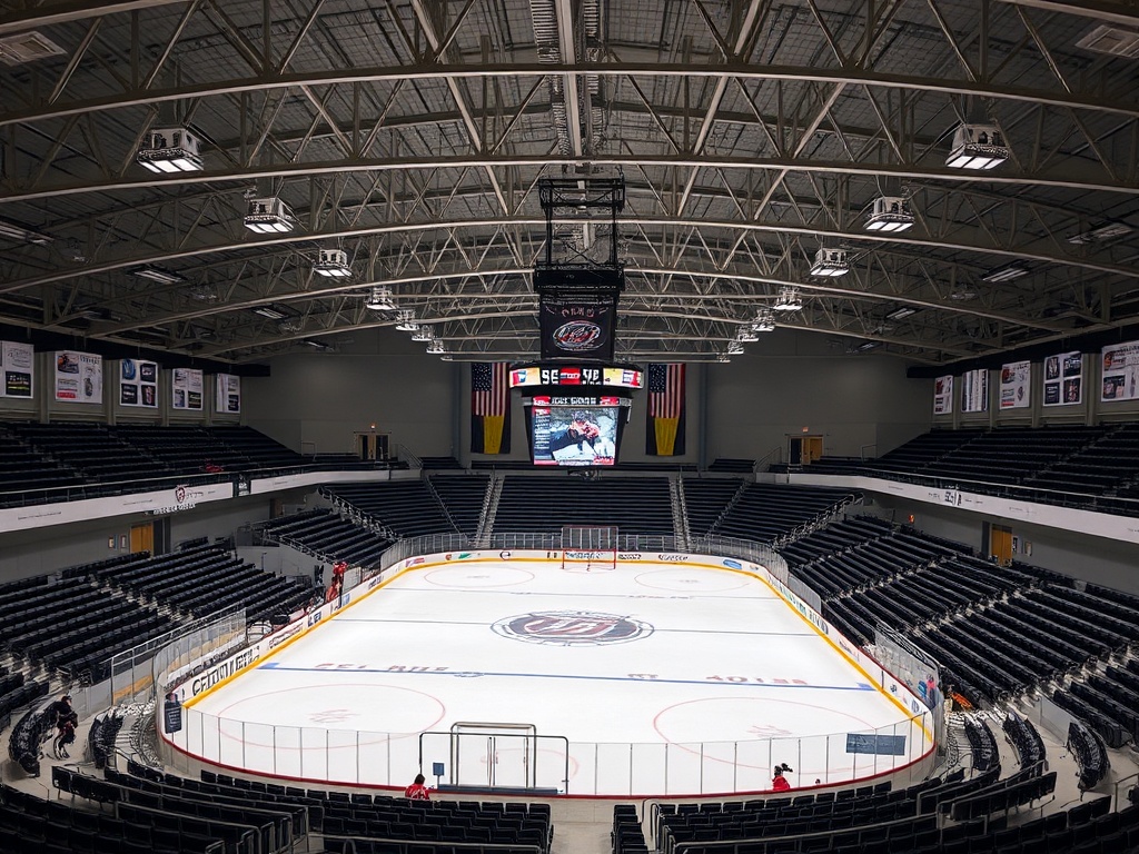 community arena interior with soft lighting, empty ice surface and seating, small town vibe