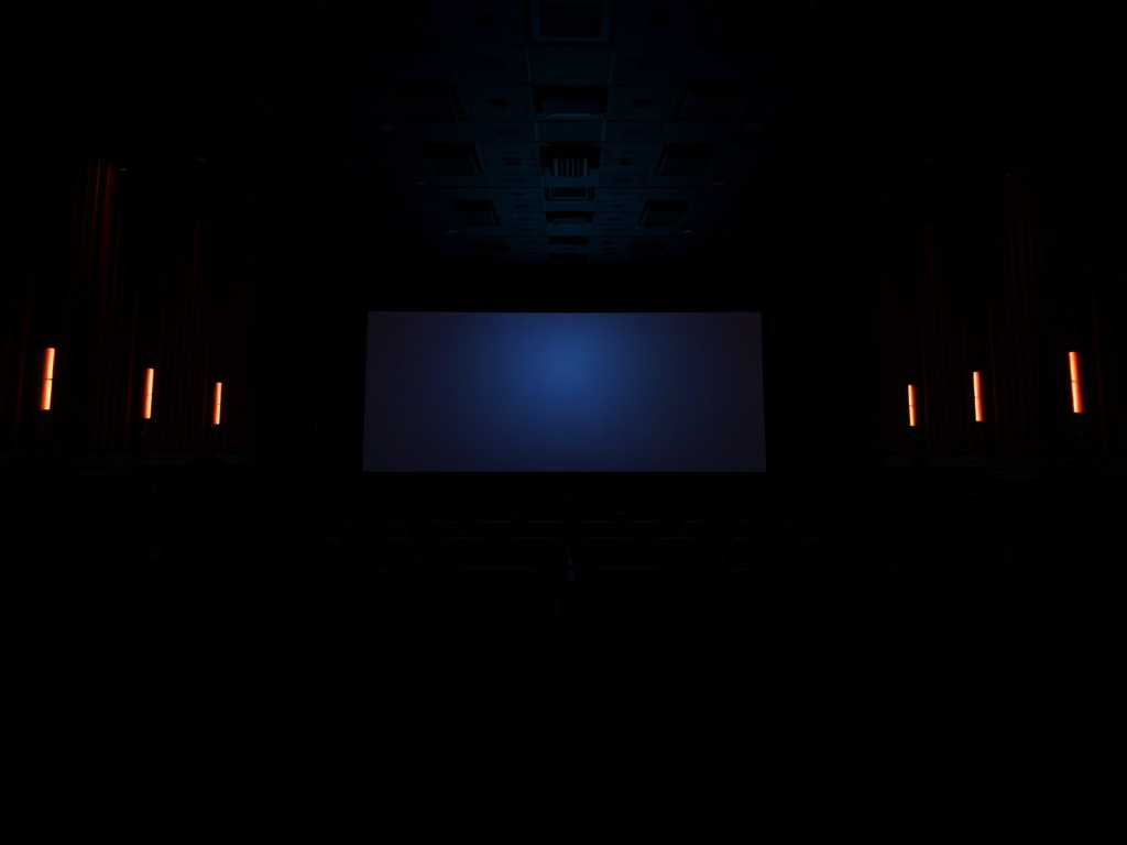 dark movie theater interior glowing screen audience silhouettes cinematic lighting