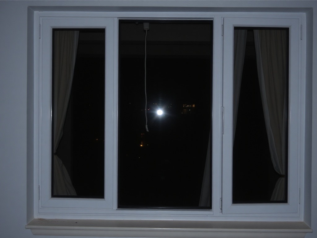 apartment window at night with no curtains, visible interior from outside