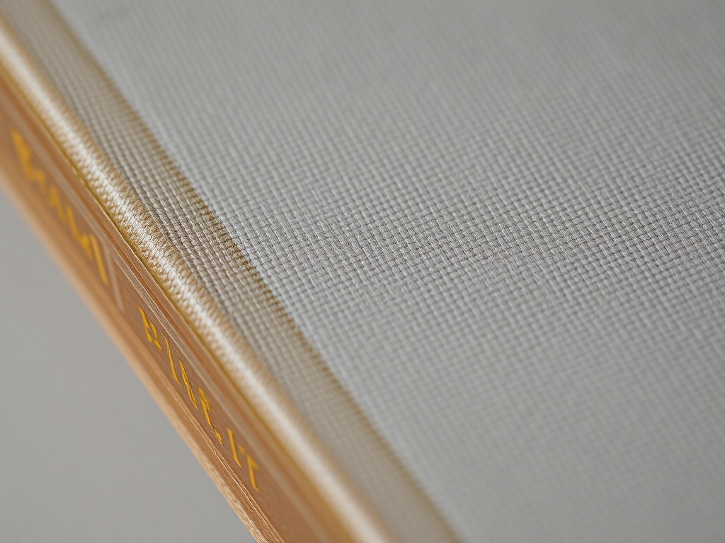 close-up of cloth book spine with gold stamping slightly faded and textured fabric visible
