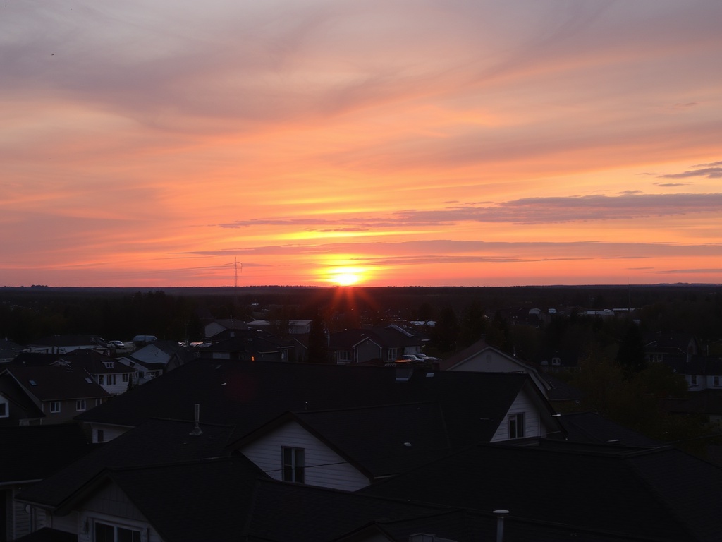 sunset over small Ontario town rooftops, warm tones, peaceful evening skyline