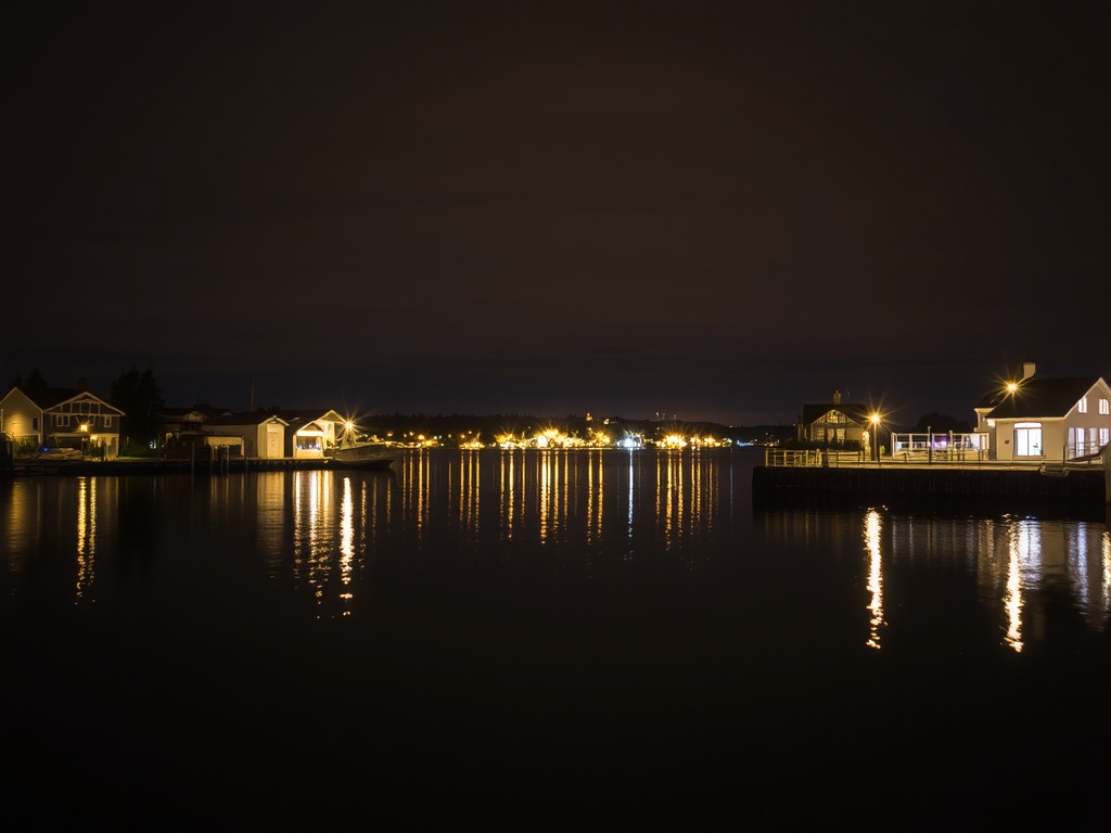 Kenora waterfront at night with reflections on water, soft lights and calm mood