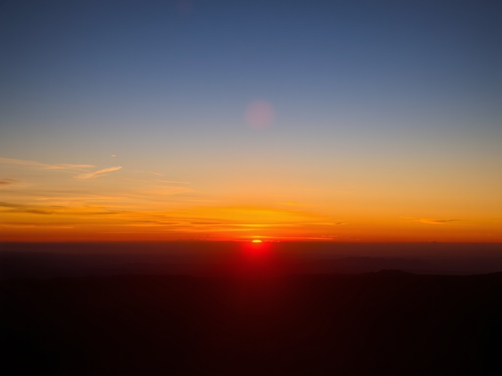 sunset over Mont-Saint-Hilaire with orange sky and silhouette of mountain, peaceful evening scene