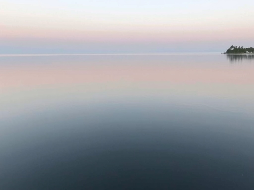 calm lakeside scene at Lake Gibson with still water, soft sky reflections, minimal people, tranquil mood